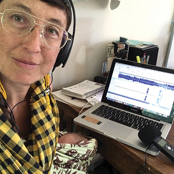 Radio DJ broadcasting at home with her laptop and microphone