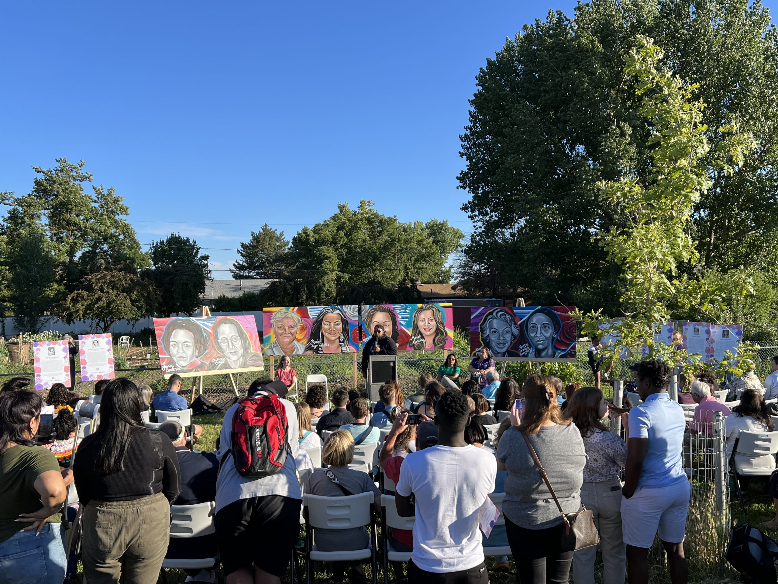 Community members photographing a newly installed women's mural at the Rose Park Community Garden